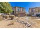 Two-story home boasts a two-car garage, neutral stucco, low maintenance landscaping, and a desert rock feature at 599 W Agrarian Hills Dr, San Tan Valley, AZ 85143