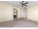 Bright, carpeted living room featuring a ceiling fan and view of kitchen with tile flooring at 599 W Agrarian Hills Dr, San Tan Valley, AZ 85143