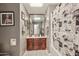 Well-lit bathroom with a vanity and storage, framed mirror, and tiled floor at 6217 W Orange Dr, Glendale, AZ 85301