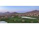 Panoramic aerial view of a golf course community with sprawling green fairways and mountain views at 7418 E Sandia Cir, Mesa, AZ 85207