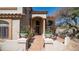 Charming front porch area with seating, a fountain feature, and colorful climbing vines on the walls at 7418 E Sandia Cir, Mesa, AZ 85207