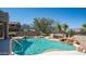 Sparkling pool features a stone waterfall, lush desert landscaping, and ample space for relaxation at 7418 E Sandia Cir, Mesa, AZ 85207