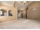 Living room with carpeted floors, neutral paint, and arched windows offering a view into the adjacent kitchen at 830 N Cholla St, Chandler, AZ 85224