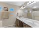 Bright bathroom featuring double sinks, a large mirror, and natural light from the windows at 9100 E Raintree Dr # 209, Scottsdale, AZ 85260