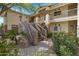 Exterior shot of building with dual concrete stairways and manicured landscaping at 9100 E Raintree Dr # 209, Scottsdale, AZ 85260