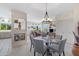 Open dining room area features a round glass table, modern chandelier, and views of the living room and outside at 9100 E Raintree Dr # 209, Scottsdale, AZ 85260