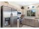 Modern kitchen featuring stainless steel appliances, light wood cabinets, tile floor, and a window overlooking trees outside at 9100 E Raintree Dr # 209, Scottsdale, AZ 85260