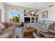 Living room features neutral walls, carpet floors, leather furniture, a fireplace, and natural lighting at 9100 E Raintree Dr # 209, Scottsdale, AZ 85260