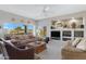 Living room with neutral walls, carpet flooring, leather furniture, a fireplace, and large windows with natural lighting at 9100 E Raintree Dr # 209, Scottsdale, AZ 85260