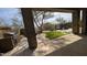 Covered outdoor kitchen with a built-in grill overlooking a pool, lush lawn, and manicured landscaping at 9435 E Mohawk Ln, Scottsdale, AZ 85255