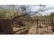 View of a desert landscaped backyard with a fence and trees, perfect for privacy at 9435 E Mohawk Ln, Scottsdale, AZ 85255