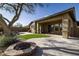 Landscaped backyard with a lush lawn, rock fire pit, and a view of the waterfall and pool at 9435 E Mohawk Ln, Scottsdale, AZ 85255