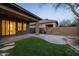 Backyard patio with a built-in grill, cozy fire pit, lush green lawn, and well-maintained landscaping at 9435 E Mohawk Ln, Scottsdale, AZ 85255