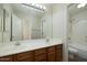 Well-lit bathroom featuring double sinks, a large mirror, and a separate toilet and shower area at 9435 E Mohawk Ln, Scottsdale, AZ 85255