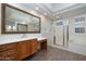 Bathroom with a large vanity, mirror, soaking tub and glass shower door at 9435 E Mohawk Ln, Scottsdale, AZ 85255