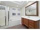 Bright bathroom with a glass shower door, soaking tub and traditional wood vanity at 9435 E Mohawk Ln, Scottsdale, AZ 85255