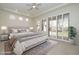 Spacious bedroom featuring tray ceilings, neutral color scheme and sliding glass doors to the backyard at 9435 E Mohawk Ln, Scottsdale, AZ 85255