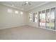 Large bedroom with neutral carpet, tray ceilings and sliding glass doors with shutter-style blinds at 9435 E Mohawk Ln, Scottsdale, AZ 85255