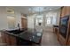 Modern kitchen features an island with a black countertop, wood cabinets, and stylish pendant lighting at 9435 E Mohawk Ln, Scottsdale, AZ 85255