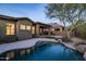 Backyard with a custom swimming pool, desert landscaping, mature trees, and covered patio at 9435 E Mohawk Ln, Scottsdale, AZ 85255