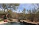 A backyard view featuring a pool, desert landscape, and distant mountain view, creating a serene retreat at 9435 E Mohawk Ln, Scottsdale, AZ 85255