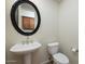 Charming powder room with pedestal sink, decorative mirror, and updated fixtures at 9435 E Mohawk Ln, Scottsdale, AZ 85255