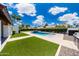Landscaped backyard features a rectangular pool and lush green lawn with palm trees under a blue sky at 9675 E Cinnabar Ave, Scottsdale, AZ 85258