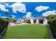 Spacious backyard featuring green lawn, a sparkling pool, and mature landscaping, perfect for outdoor activities at 9675 E Cinnabar Ave, Scottsdale, AZ 85258