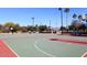 Outdoor basketball court with hoops, benches, and lighting surrounded by lush greenery and mature trees at 9675 E Cinnabar Ave, Scottsdale, AZ 85258