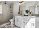 Bright bathroom featuring double sinks with white cabinets and a spacious glass enclosed shower with rain shower head at 9675 E Cinnabar Ave, Scottsdale, AZ 85258