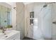 Elegant bathroom featuring a sink, glass shower with rain shower head, and white marble styled walls at 9675 E Cinnabar Ave, Scottsdale, AZ 85258