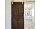 Bathroom with a designer wood sliding door leading to a double sink vanity and herringbone tile floor at 9675 E Cinnabar Ave, Scottsdale, AZ 85258