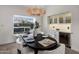 Dining area with a stylish light fixture, wine fridge and custom cabinetry creating a luxurious ambiance at 9675 E Cinnabar Ave, Scottsdale, AZ 85258