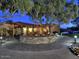 Modern single-story home features a circular driveway and lush desert landscaping with mature trees at 9675 E Cinnabar Ave, Scottsdale, AZ 85258