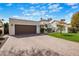 Exterior of modern home with brown garage door and well-manicured landscaping at 9675 E Cinnabar Ave, Scottsdale, AZ 85258