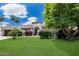 Beautiful home featuring a well-maintained lawn, mature landscaping, and a circular driveway for easy access at 9675 E Cinnabar Ave, Scottsdale, AZ 85258