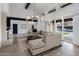 Spacious living area with tiled floors and modern decor flows into adjacent kitchen; view of pool through doors at 9675 E Cinnabar Ave, Scottsdale, AZ 85258