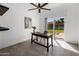 Bright office space with a dark desk, neutral-colored chair, and a sliding glass door overlooking the backyard at 9675 E Cinnabar Ave, Scottsdale, AZ 85258