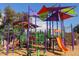 Colorful playground featuring climbing structures, slides, and play areas on a wood chip surface at 9675 E Cinnabar Ave, Scottsdale, AZ 85258