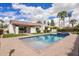 Backyard pool with brick patio and desert landscaping surrounding a white, modern home at 9675 E Cinnabar Ave, Scottsdale, AZ 85258