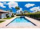 Sparkling pool with brick surround, complemented by lush landscaping and blue skies at 9675 E Cinnabar Ave, Scottsdale, AZ 85258