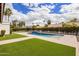 Backyard pool with grass and brick border on a sunny day at 9675 E Cinnabar Ave, Scottsdale, AZ 85258