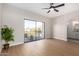 Bright bedroom with wood floors, ceiling fan, and sliding glass door leading to a balcony, offering a blend of comfort and style at 9705 E Mountain View Rd # 1056, Scottsdale, AZ 85258