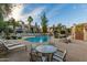 A community pool surrounded by chairs, tables, and palm trees for residents to enjoy at 9705 E Mountain View Rd # 1056, Scottsdale, AZ 85258