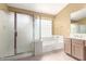 Bathroom with shower stall, bathtub, and spacious countertop with ample lighting at 10012 W Runion Dr, Peoria, AZ 85382