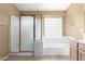 Bathroom featuring a glass enclosed shower, tub and single sink at 10012 W Runion Dr, Peoria, AZ 85382
