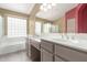 Bathroom featuring double sinks, a large mirror, and natural light from glass block window at 10012 W Runion Dr, Peoria, AZ 85382