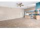 Open-concept living room featuring tile floors, a ceiling fan, and an adjacent kitchen at 10012 W Runion Dr, Peoria, AZ 85382