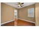 Neutral bedroom boasts wood floors, ceiling fan, window with shutter and a walk-in closet at 10334 E Radiant Ave, Mesa, AZ 85212