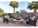 Backyard patio featuring outdoor seating, fire pit, palms, and decorative fountain at 1197 W Rolls Rd, San Tan Valley, AZ 85143